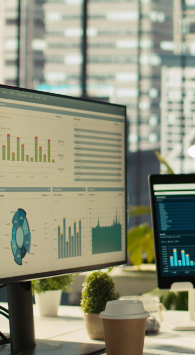 Illustration of a computer screen with a magnifying glass over data charts, surrounded by various data icons.