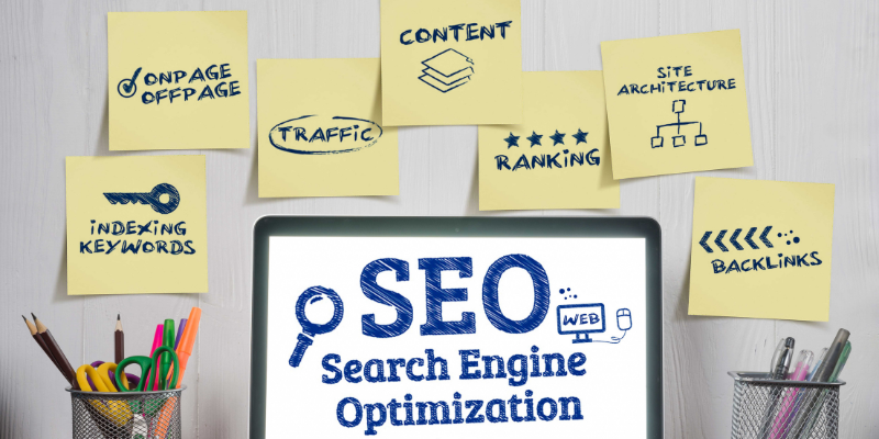 Computer screen displaying "SEO Search Engine Optimization" surrounded by sticky notes